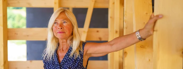 Opgewonden Senior Vrouw Haar Onvoltooide Ecologische Houten Huis — Stockfoto