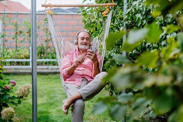 Homem Sênior Feliz Sentado Balanço Jardim Ouvir Música Fones Ouvido — Fotografia de Stock