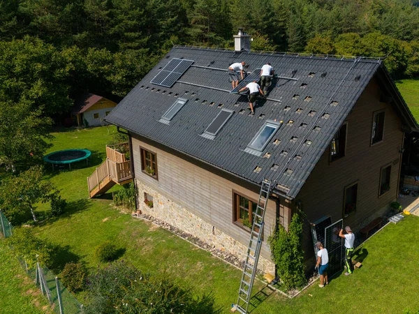 屋根に太陽光発電パネルを設置する男性労働者の高い角度のビュー 代替エネルギー 省資源と持続可能なライフスタイルの概念 — ストック写真