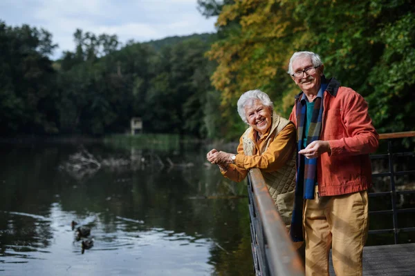 Szczęśliwa Para Seniorów Jesiennym Spacerze Nad Jeziorem Mając Przerwę — Zdjęcie stockowe