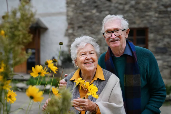 Szczęśliwa Para Seniorów Jesiennym Spacerze Mieście Pozowanie Kwiatami — Zdjęcie stockowe