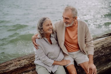 Kıdemli çift sonbahar denizinde oturuyor ve romantik anlar yaşıyorlar..