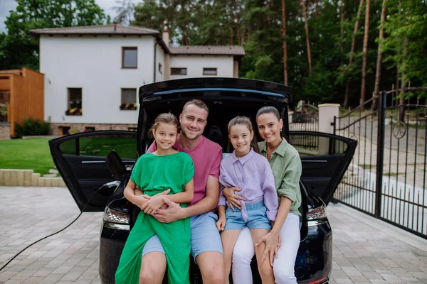 Família Feliz Sentado Porta Malas Carro Esperando Carregamento Carro Elétrico — Fotografia de Stock