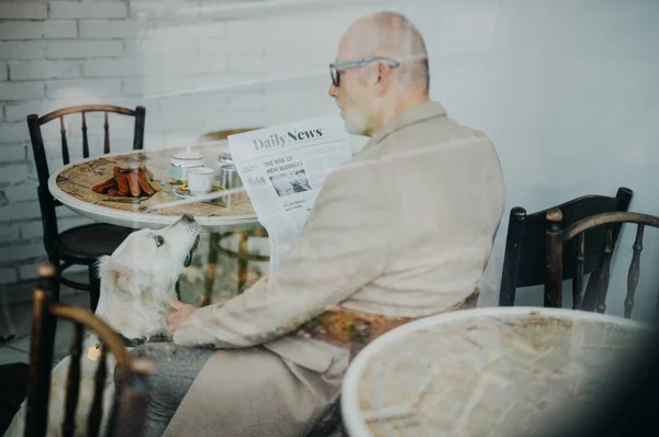 Happy Senior Man Sitting Cafeteria His Dog Reading Newspaper — Stock Photo, Image
