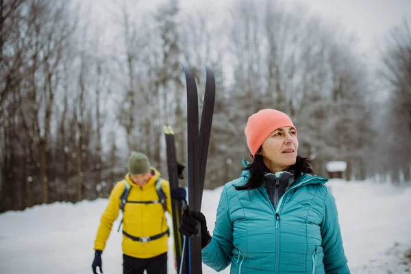 冬の森をスキーで横断するシニアカップル — ストック写真