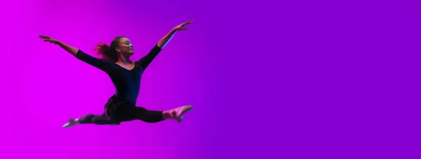 Танцовщица Танцовщица Прыгающая Неоновом Свете Занимающаяся Гимнастикой Студии Широким Баннером — стоковое фото