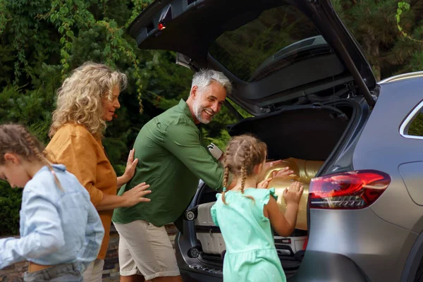 가족들은 자동차가 충전되는 휴일을 가방을 자동차 트렁크에 — 스톡 사진
