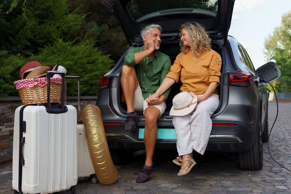Middle Aged Couple Sitting Trunk While Waiting Charging Car Travelling — Stock fotografie
