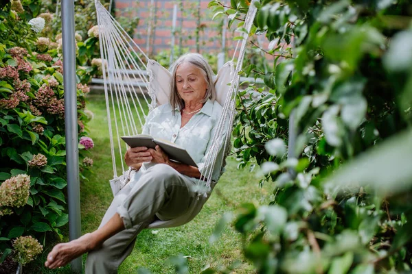 Старша Жінка Розслабляється Саду Гойдалки Книгою — стокове фото