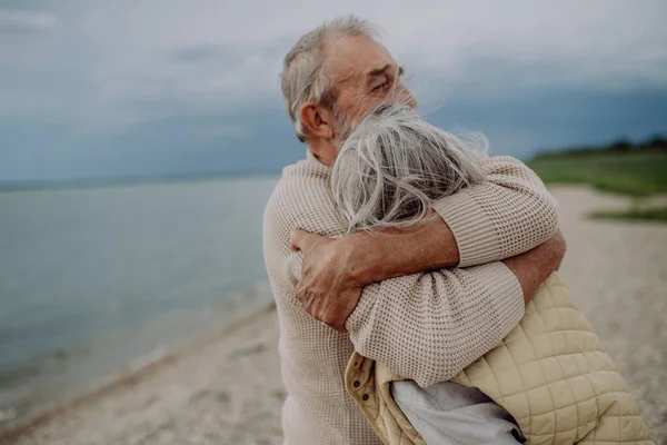 秋の海の近くでロマンチックな瞬間を持って お互いを受け入れる愛のシニアカップル — ストック写真