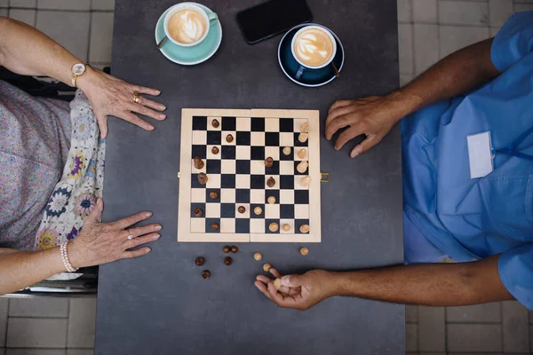 Draufsicht Des Betreuers Beim Schachspielen Und Kaffeetrinken Mit Seinem Klienten — Stockfoto