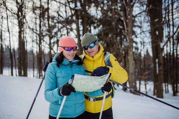 Seniorenpaar Schaut Beim Langlaufen Verschneiter Natur Auf Papierkarte — Stockfoto