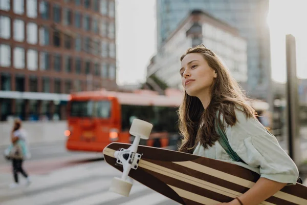スケートボードで街を歩く若い女性 若者文化と通勤概念 — ストック写真