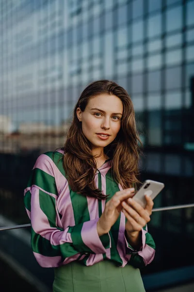 在日落时分 城市里一个带着智能手机的年轻漂亮女子的画像 — 图库照片