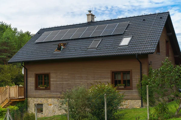 父亲和他的小儿子从天窗望着屋顶上的太阳能电池板 替代能源 节约资源和可持续生活方式概念 — 图库照片