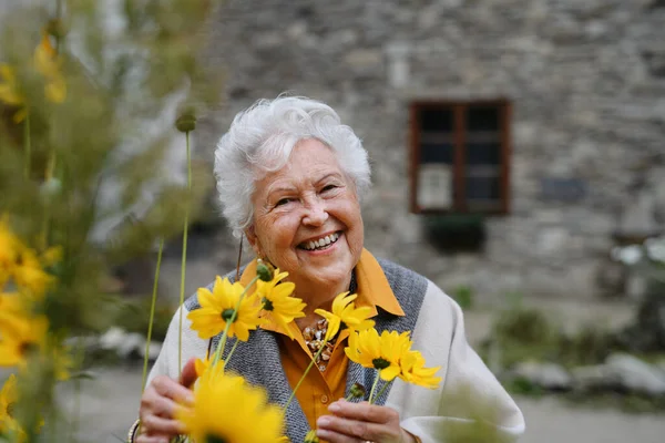 Портрет Счастливой Пожилой Женщины Стоящей Открытом Воздухе Позирующей Цветами — стоковое фото
