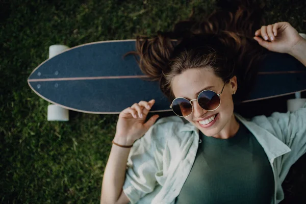 Pemandangan Utama Wanita Muda Berbaring Rumput Dengan Skateboard — Stok Foto