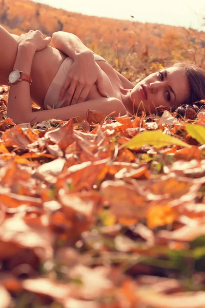 Mujer acostada sobre hojas caídas — Foto de Stock