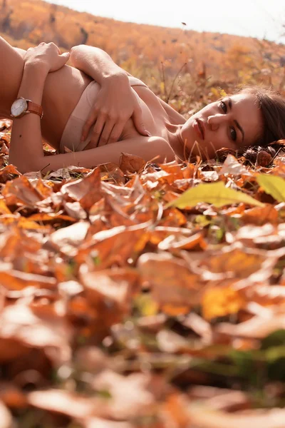 Žena leží na spadané listí — Stock fotografie