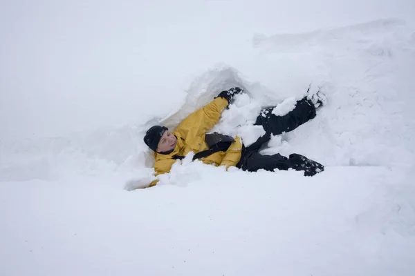 Ung man, liggande i snön — Stockfoto