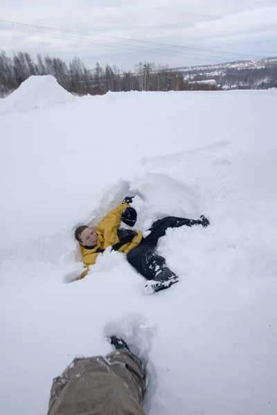Молодой человек лежит в снегу — стоковое фото
