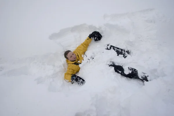 Молодой человек лежит в снегу — стоковое фото