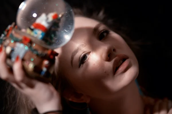 Girl holding a snow globe. — Stock Photo, Image