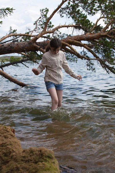 Meisje een witte jas lopen in het water — Stockfoto