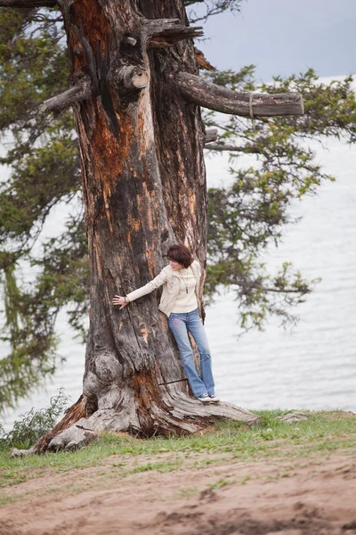 Νεαρή γυναίκα να στέκεται κοντά σε ένα τεράστιο δέντρο — Φωτογραφία Αρχείου