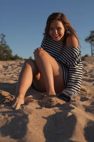 Schönes Mädchen sitzt am Strand — Stockfoto