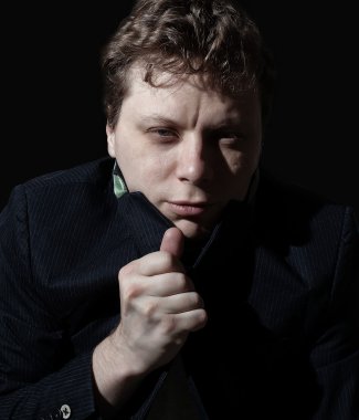 Siyah arka planda genç bir adamın portresi.