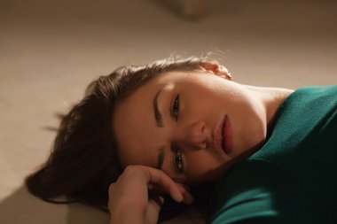 Genç kadın yerde yatıyor.