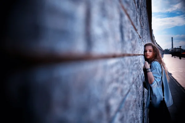 Blond woman by wall — Stock Photo, Image