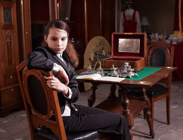 Girl sat in antique shop — Stock Photo, Image