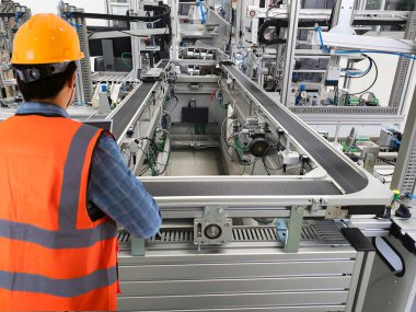 Engineers use technology to control production machinery in industrial plants.