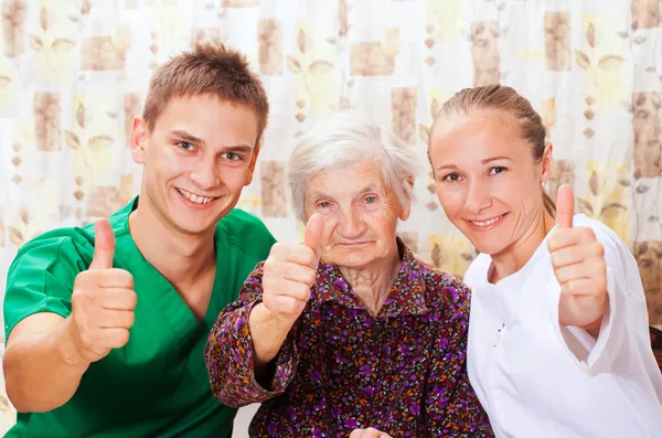 Femme âgée avec les jeunes médecins — Photo