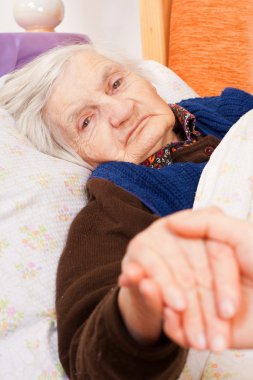 yaşlı yalnız kadın yatakta yatıyor