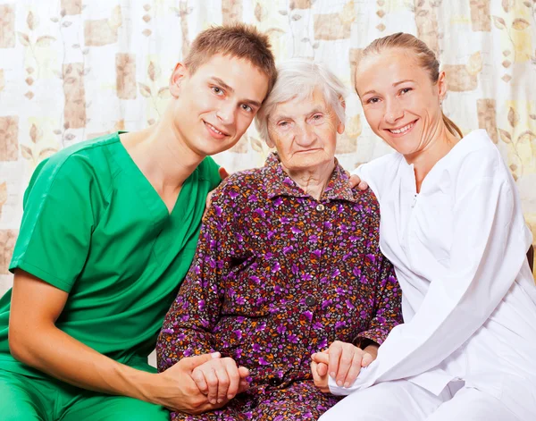 Mujer mayor con los médicos jóvenes —  Fotos de Stock