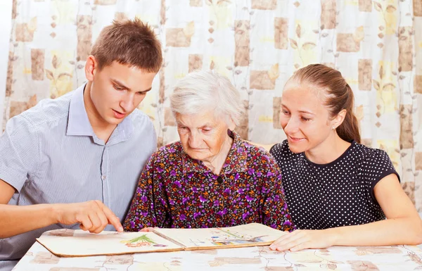 Пожилая женщина с двумя молодыми улыбающимися внуками — стоковое фото