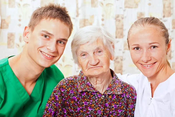 Пожилая женщина с молодыми врачами — стоковое фото