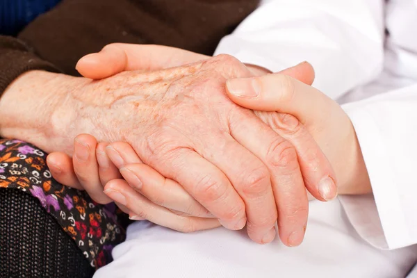 Joven médico sostiene las manos de la anciana — Foto de Stock