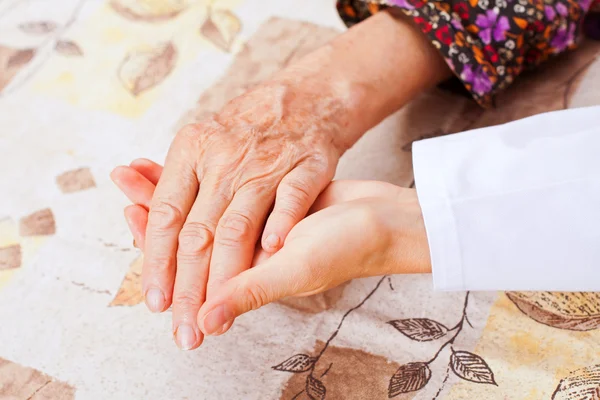 젊은 의사는 노인 여성 손 보유 하 — 스톡 사진