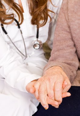 yaşlı adam genç doktor tutar