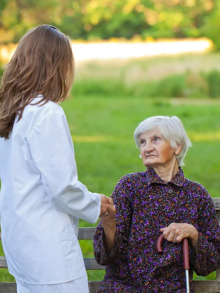 Yaşlı kadın genç bir doktor ile — Stok fotoğraf