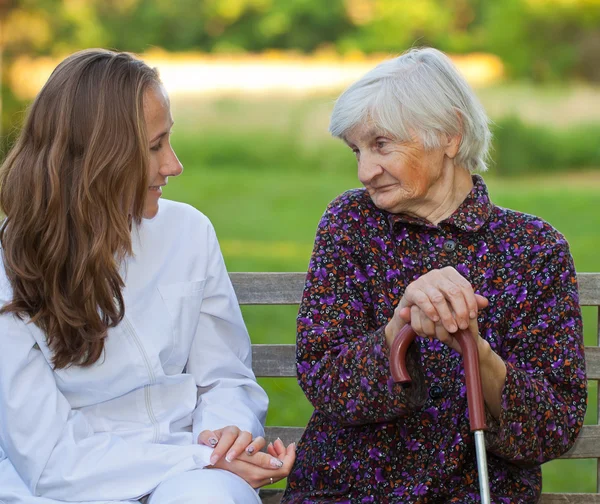 Äldre kvinna med unga läkare — Stockfoto
