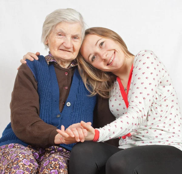 The sweet young girl and the old woman staying together — Stock Photo, Image