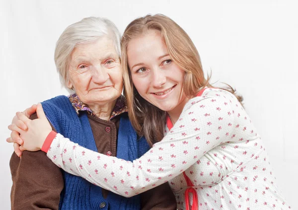 The sweet young girl and the old woman staying together — Stock Photo, Image