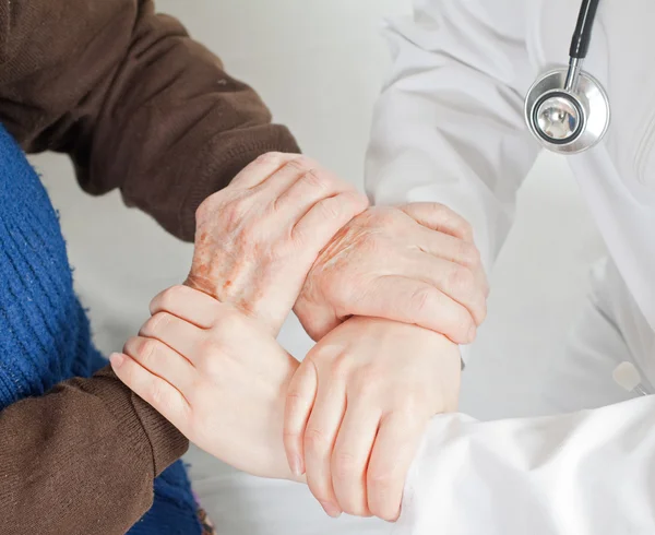 Young sweet doctor holds the old woman — Stock Photo, Image