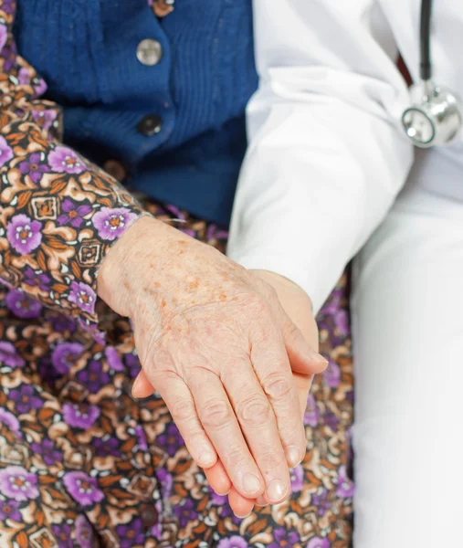 Yaşlı kadın genç tatlı doktor tutar — Stok fotoğraf