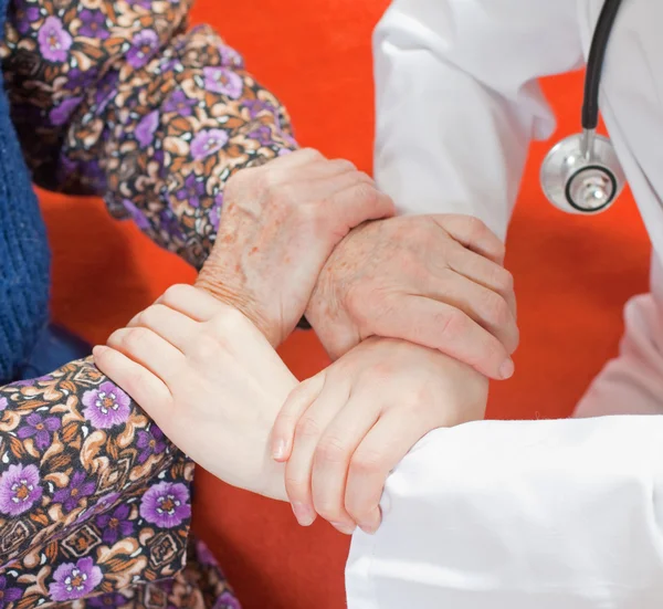 Yaşlı kadın genç tatlı doktor tutar — Stok fotoğraf